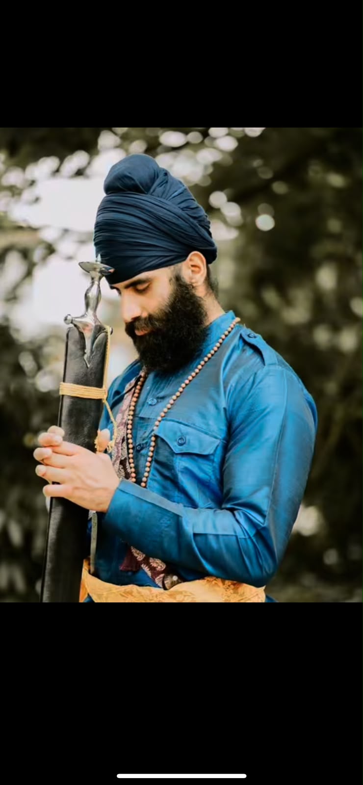 Karan Singh Bains wearing a blue turban and traditional blue clothing